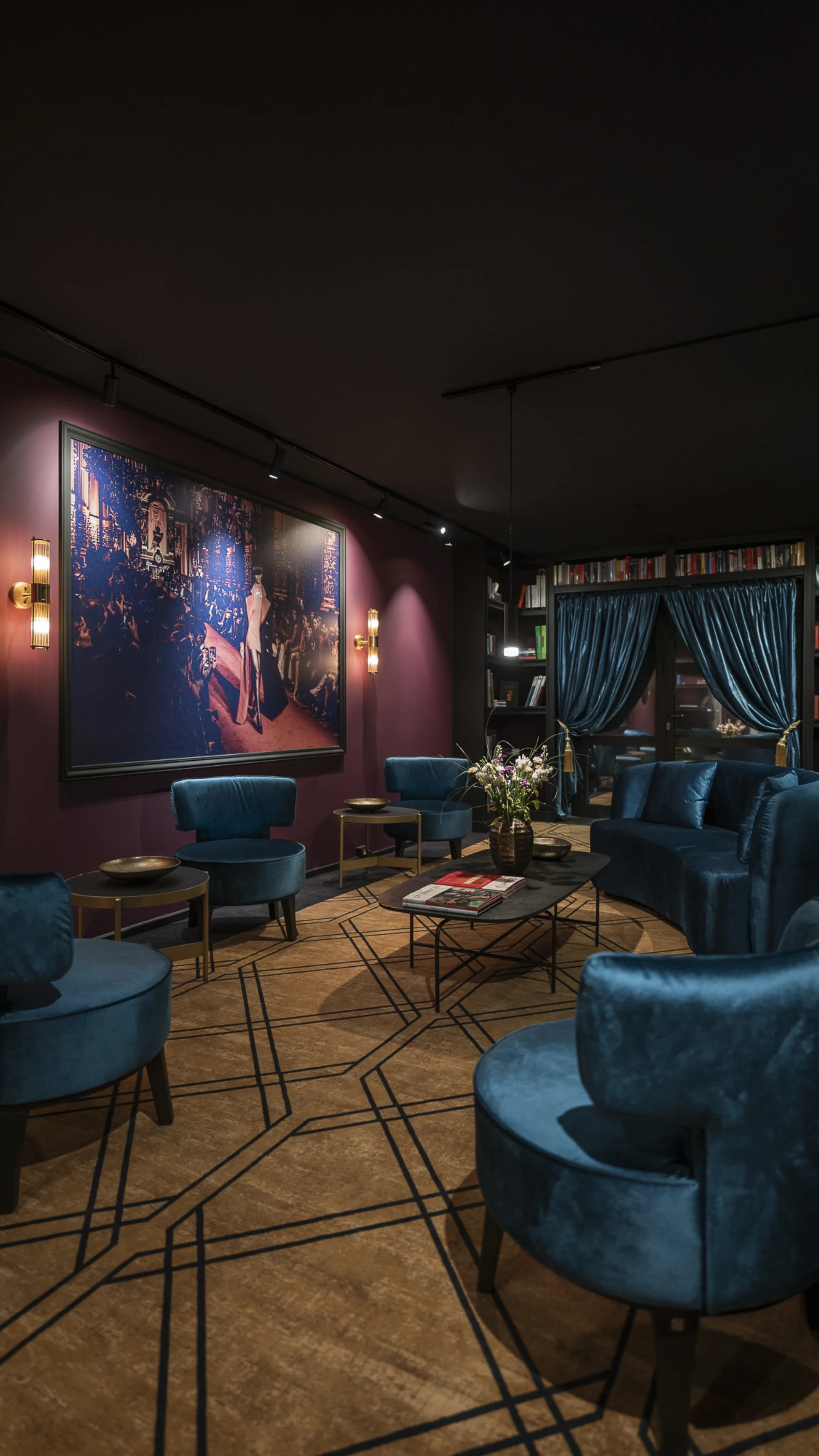 Leipzig Suites Welcomelounge mit Bibliothek und blauem Samtvorhang — Rückzugsort für Langzeitgäste Leipzig Suites Welcomelounge mit Bibliothek und blauem Samtvorhang — Rückzugsort für Langzeitgäste